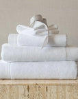 Product image. Stack of white cosima towels in every size