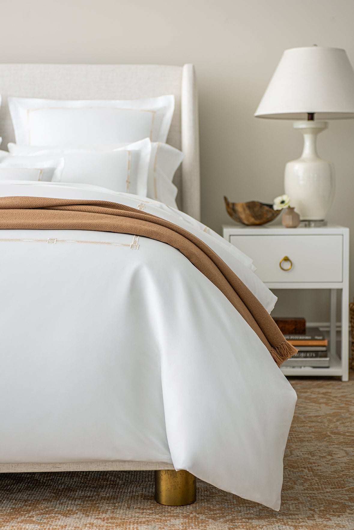 close up of the Lisetta Duvet cover in champagne with the Savona throw in camel