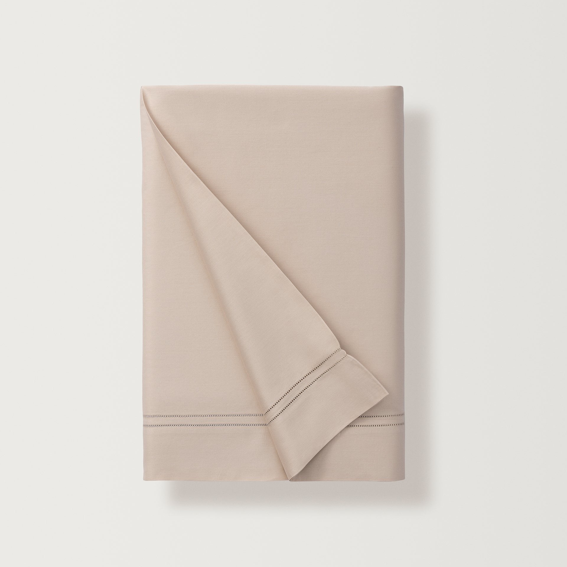the flat sheet in the color fawn, finished with a double-row hemstitch, adds a touch of formal flair to the super-fine sateen, elevating both the look and feel of the sheet.