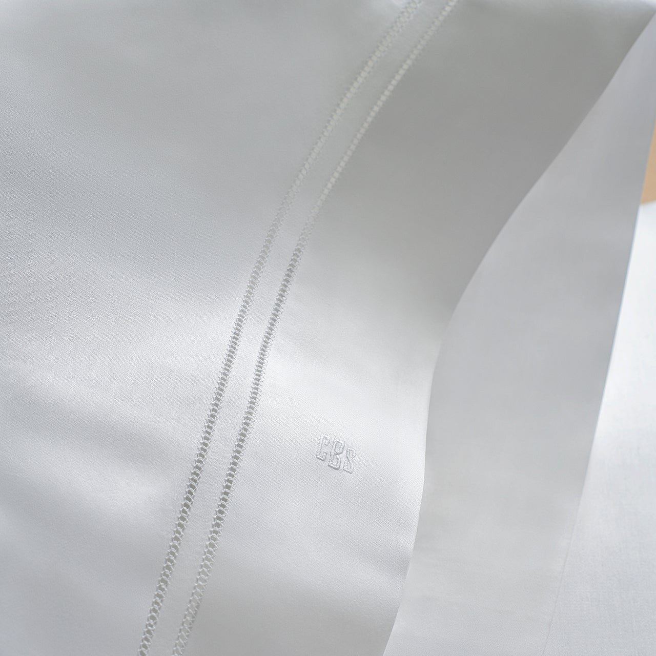 close up the double hemstitch detail of the Lucea Pillowcase in white  and the monogram