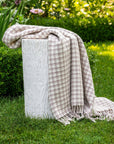 Our torcello throw is available in a beautiful houndstooth pattern in the color taupe. 70% Merino Wool, 30% Cashmere Handloomed in Nepal