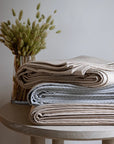 Stacked image of Ravello Coverlets in all three colors: linen, cove and pearl
