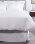 Alesandra percale knife edge duvet cover in the color white. Features a button closure and ribbon ties inside each corner