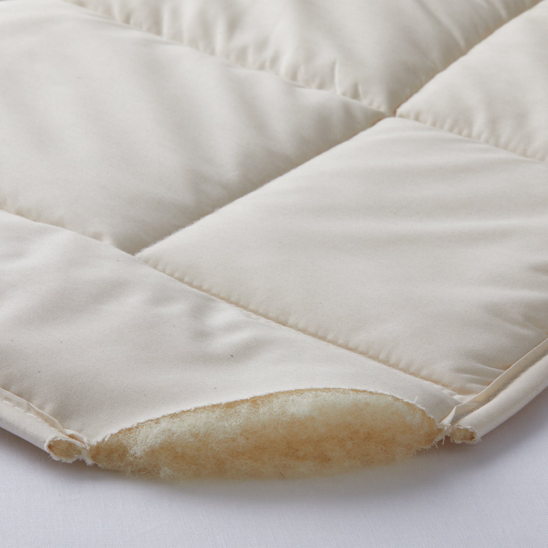 detail of the bio wool mattress pad of 100% merino pure wool inside and 100% cotton pad fabric outside