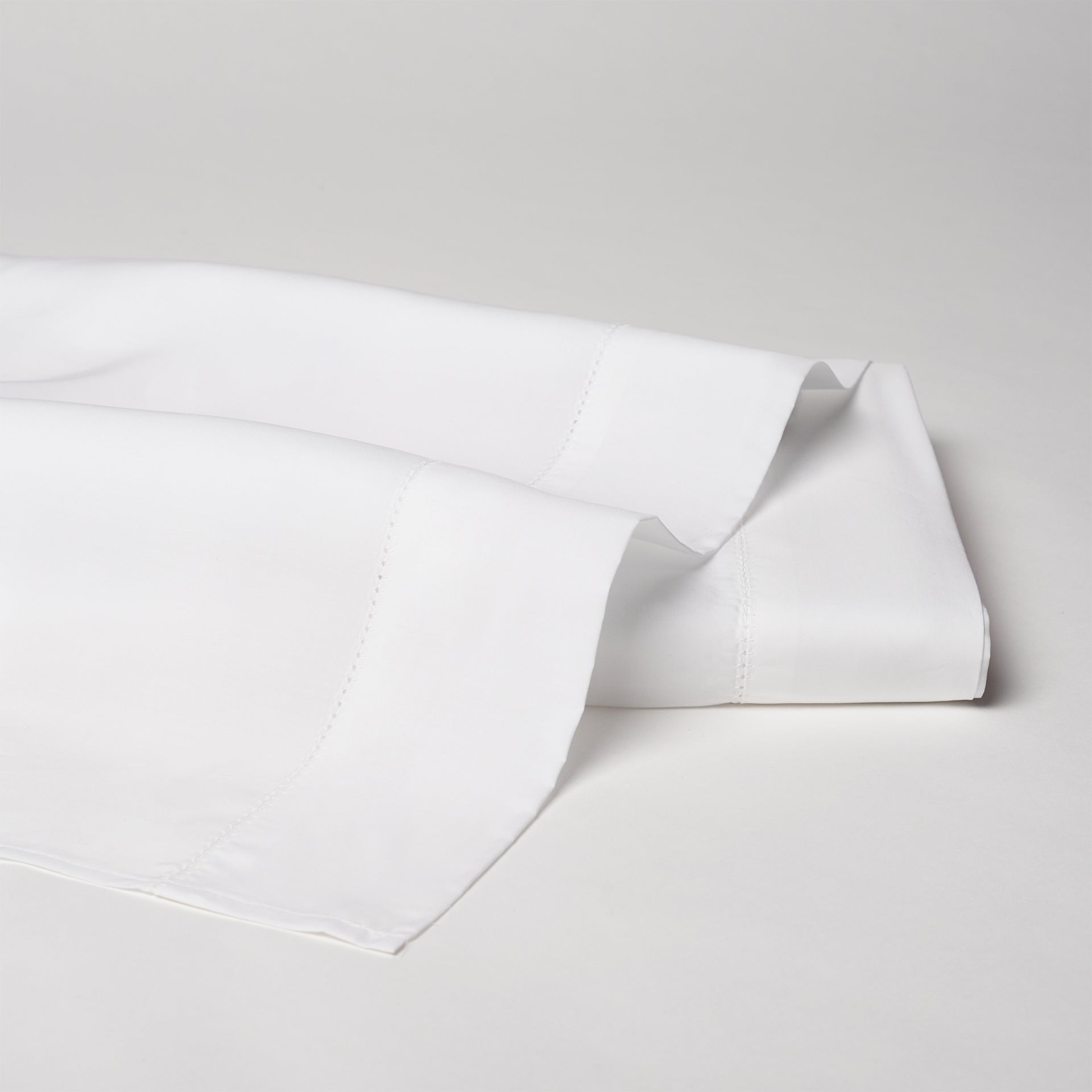 Offered in classic ivory and white, with an attractive hemstitch border on the flat sheets and pillowcases.