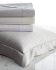 savoia stripe pillow sham shown with folded flat sheets in color ways-white, ivory and shadow