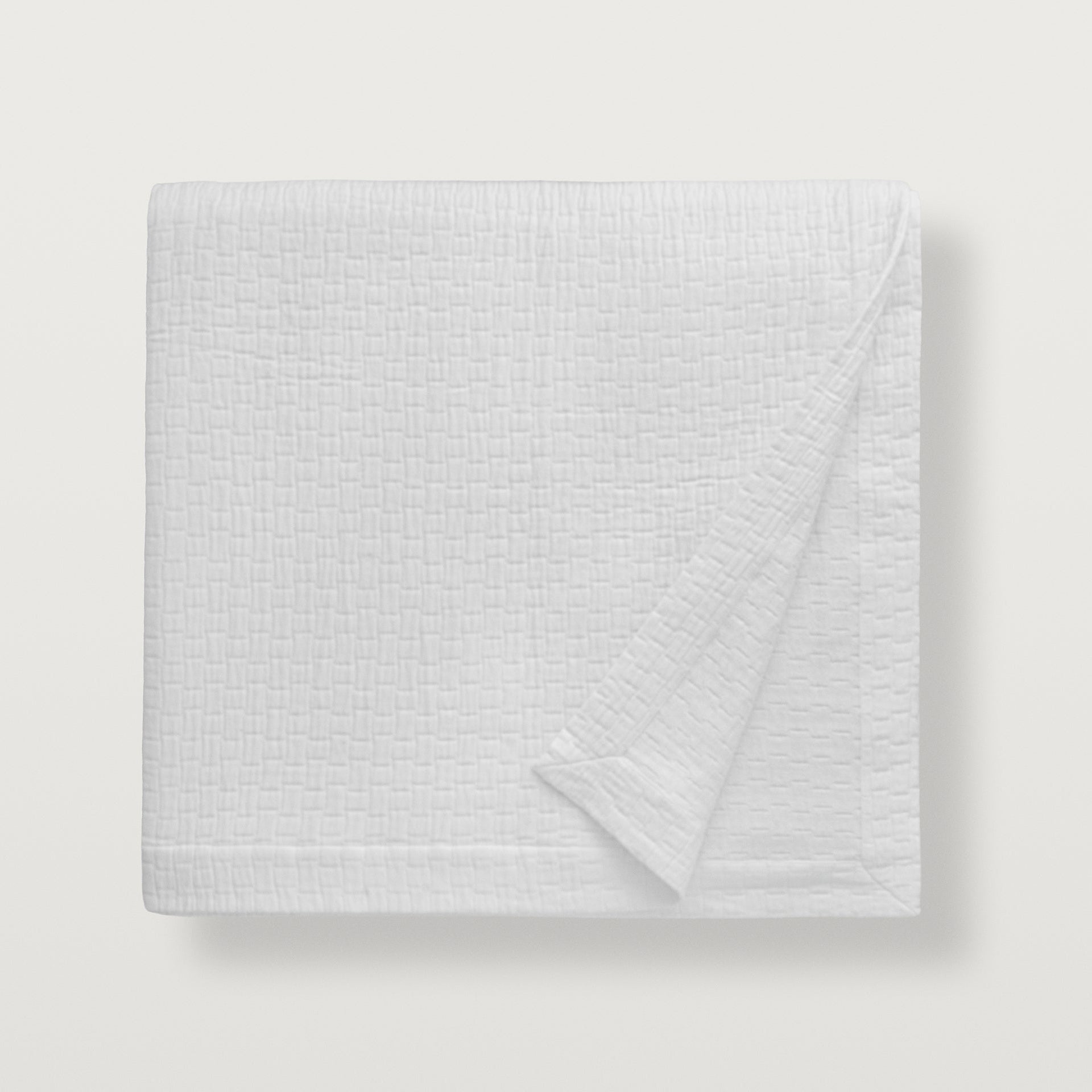 Portia coverlet in a classic cotton matelassé woven into a beautifully modern basketweave design, offered in the color white #color_white