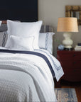 Portia coverlet in white paired with our arezzo marine embroidered sheeting
