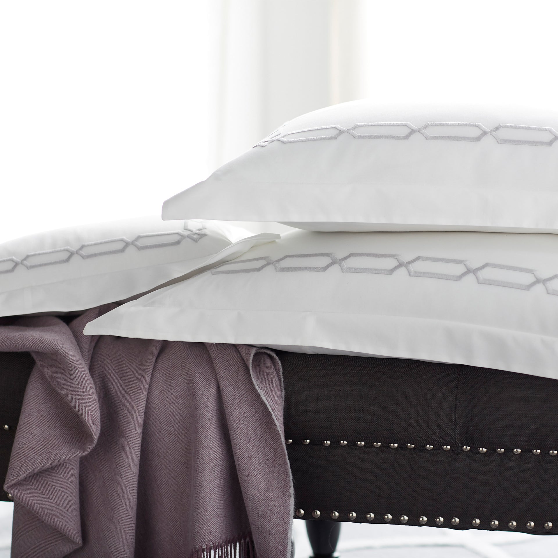 arezzo embroidered standard shams in the color shadow &amp; white on bench with cashmere blanket, 