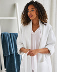 Each beautifully tailored robe features a shawl collar, deep patch pockets, and a self belt. Offered in classic white.