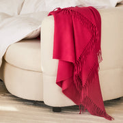 the jaya cashmere throw in the color fuschia drapped across a couch paired with our scandia comforter