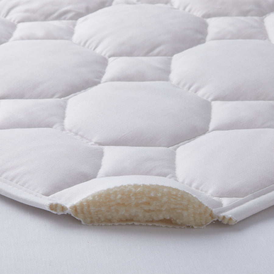 detail of the pure cotton mattress pad of 100% pure cotton inside and 100% cotton pad fabric outside