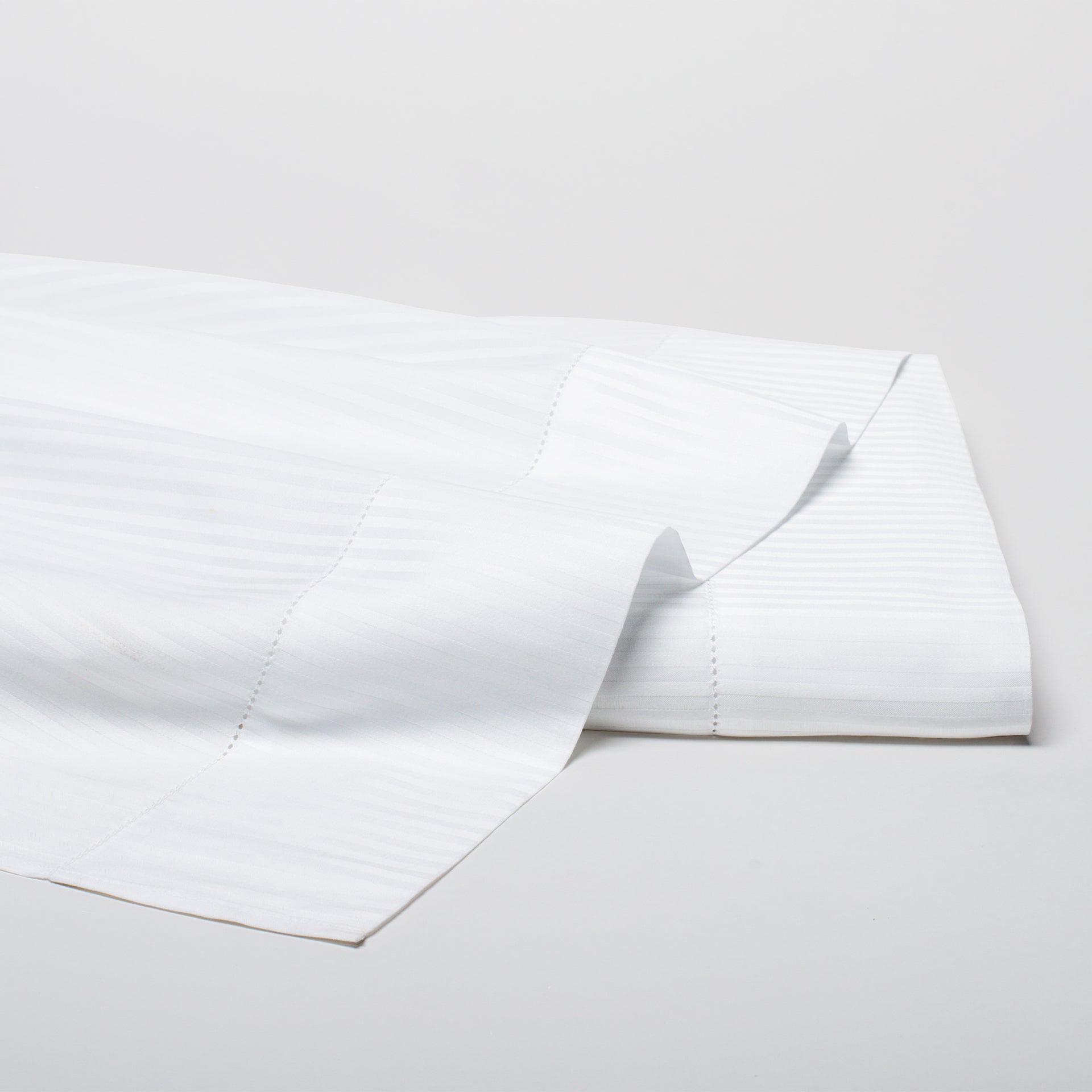 savoia stripe sateen flat sheet with a 4inch hemstitch finish shown in the color white