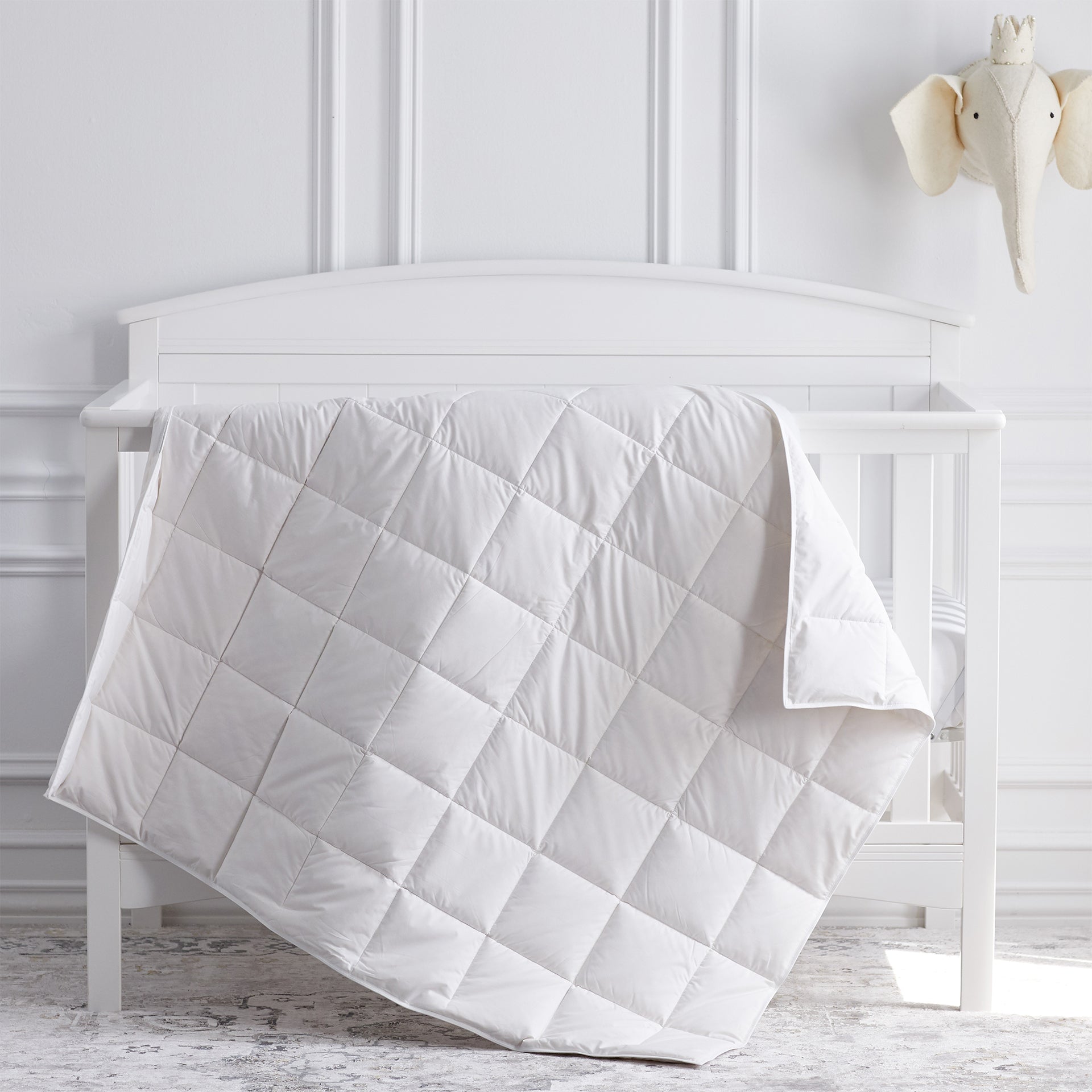 scandia home crib comforter in our classic white shell filled with european white down drapped over a crib