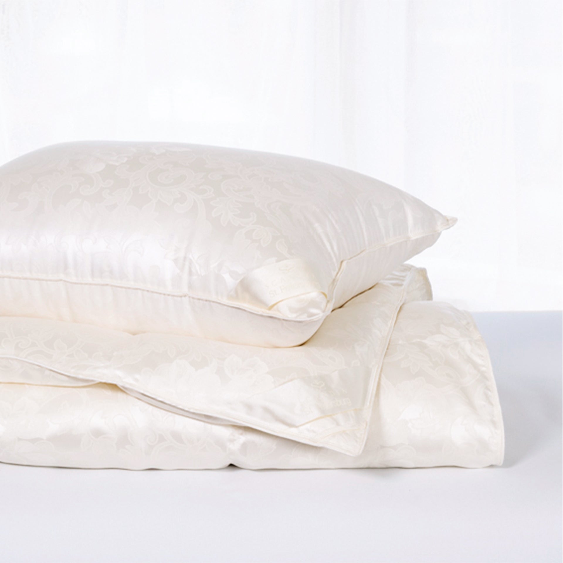 scandia home st.petersburg pillow on top of a folded st. petersburg comforter 