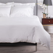 stresa sateen knife edge duvet cover in the color white. Features a button closure and ribbon ties inside each corner  