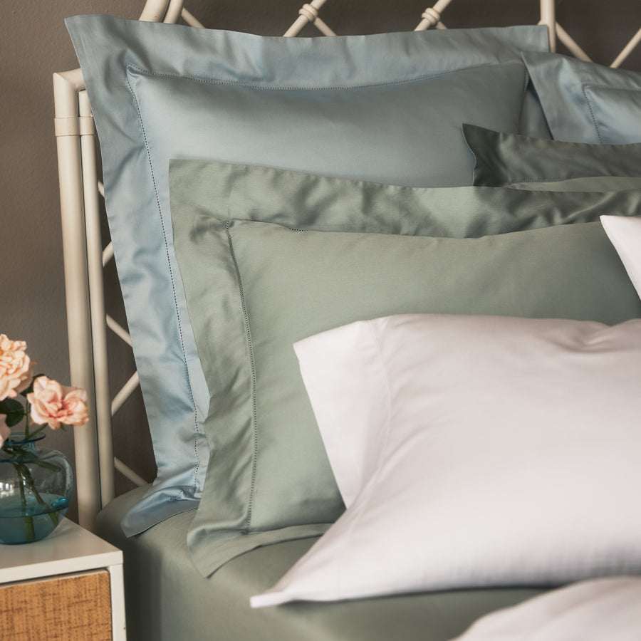 stresa sateen euro shams in the color rain, standard shams in the color heath paired with white pillowcases